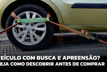 A imagem mostra um veículo preso sobre um veículo de guincho. especificamente a roda está presa e a foto foca exatamente neste ponto da imagem. Parte da carenagem do veículo é mostrada e a pintura é na cor amarela. Isso representa a busca e apreensão de veículo.