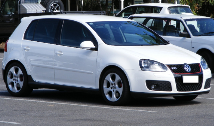 Foto de um Golf GTi branco estacionado em um estacionamento de asfalto.