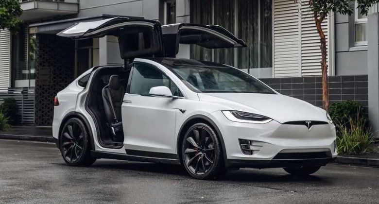 Foto do Tesla Model X estacionado com as portas abertas
