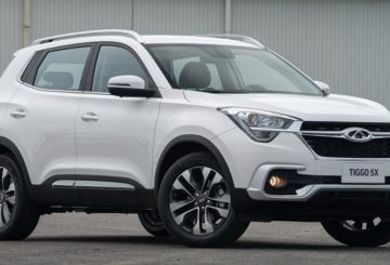 Foto de um Chery Tiggo 5X branco estacionado em frente a um portão branco.