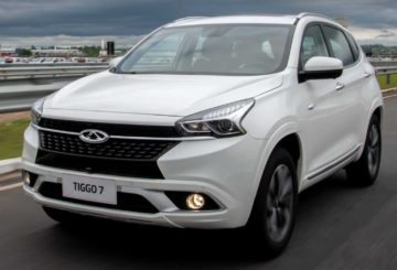 Foto de um Chery Tiggo 7 branco sendo dirigido em uma estrada asfaltada.