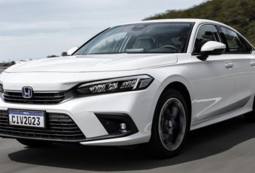 Foto da dianteira de um Honda Civic 2023, G11, branco sendo dirigido em uma estrada.
