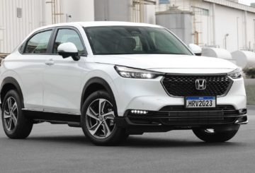 Foto de um Honda HR-V 2023, G3, branco estacionado de frente em uma rua asfaltada.
