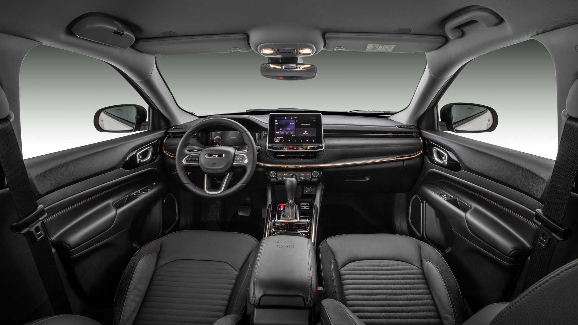 Foto do espaço interno do carro mostrando o volante, o câmbio, o painel ...