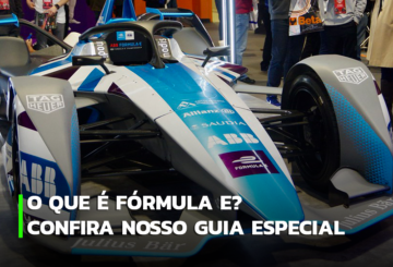 A imagem mostra um carro de Fórmula E nas cores azul e branco, exposto em um lugar de livre circulação, para que as pessoas possam observar.