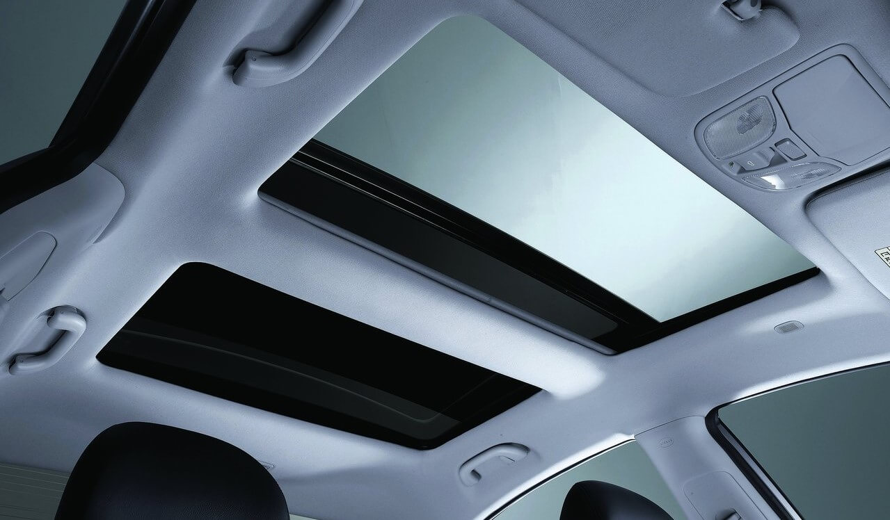 Foto de detalhe mostrando o teto solar do carro aberto.