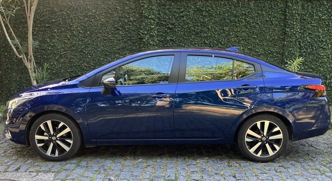 Foto mostrando a lateral esquerda de um Nissan Versa 2023 azul