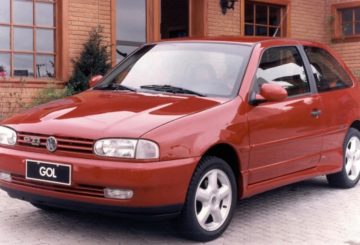 Foto mostrando a dianteira de um Volkswagen Gol G2 vermelho estacionado em uma rua de asfalto