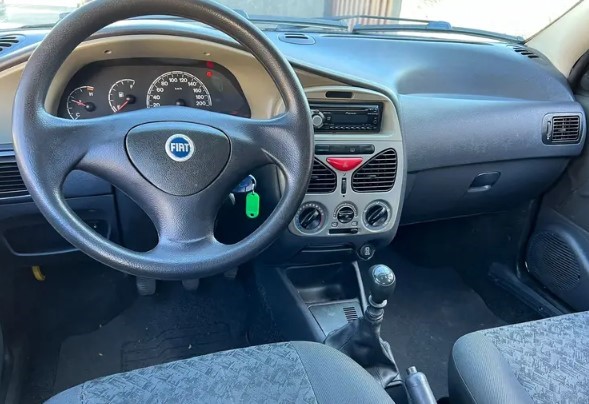 Foto mostrando o painel do carro. É possível ver o volante, o ...