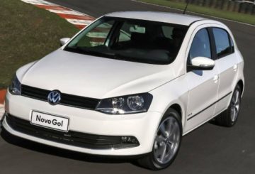 Foto mostrando a diagonal esquerda de um Volkswagen Gol 2013 branco que está sendo dirigido em uma pista de corrida.