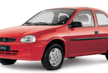 Foto feita em estúdio mostrando a diagonal esquerda de um Chevrolet Corsa Wind 2001 vermelho.