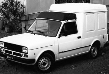 Foto mostrando a diagonal esquerda de um Fiat 147 Fiorino branco.