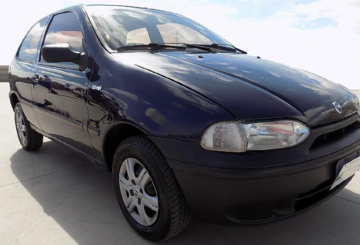 Foto mostrando a diagonal direita de um Fiat Palio EDX 1997 azul estacionado.