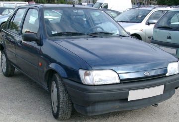 Foto mostrando a dianteira de um Ford Fiesta 1995 (G3) azul estacionado.