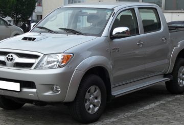 Foto mostrando a dianteira de um Toyota Hilux G7 prateado parado em um estacionamento.
