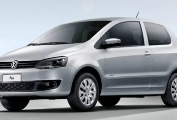 Foto feita em estúdio mostrando a diagonal esquerda de um Volkswagen Fox 2011 prateado.