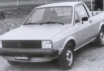 Foto mostrando a dianteira de um Volkswagen Saveiro G1 prateado estacionado em um terreno.