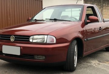 Foto mostrando a dianteira de um Volkswagen Saveiro G2 vinho estacionado em frente a uma casa.