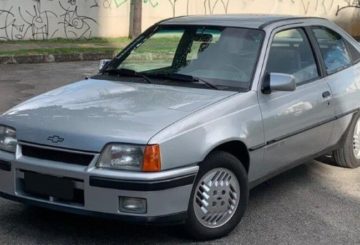 Foto mostrando a dianteira de um Chevrolet Kadett prateado estacionado.