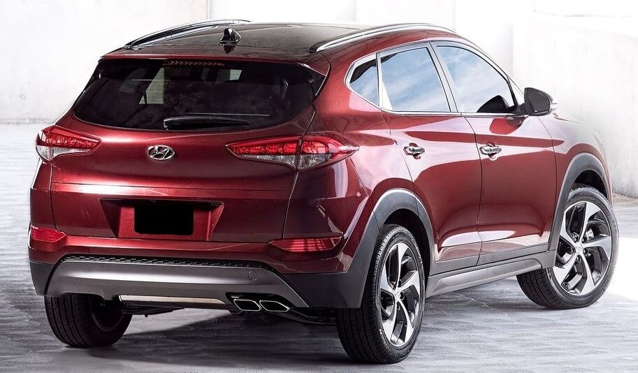 Foto mostrando a traseira de um Hyundai Tucson G3 vermelho estacionado.