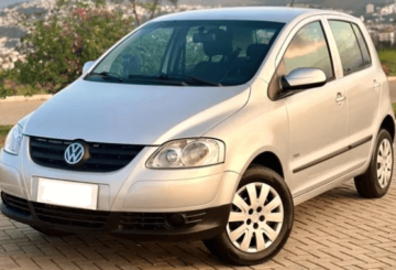 Foto mostrando a diagonal esquerda de um Volkswagen Fox 2009 prateado estacionado.