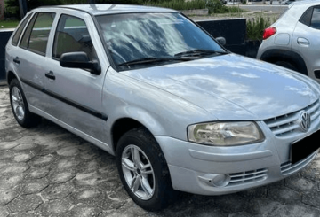 Foto mostrando a diagonal direita de um Volkswagen Gol 2013 G4 prateado estacionado.