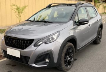 Foto mostrando a dianteira de um Peugeot 2008 Style 2023 cinza estacionado.