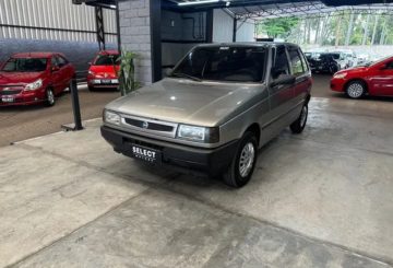 Foto exibindo a frente e as portas do lado do motorista do Fiat Uno Mille Fire 2002.