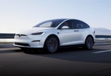 Foto do Tesla Model X, exibindo parte da frente e das portas do lado do motorista.