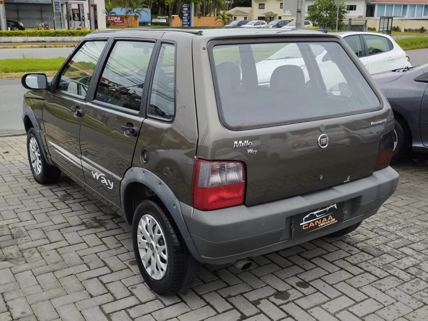 Foto da traseira do Fiat Uno Way Economy 2013, mostrando o porta-malas e a lateral do motorista