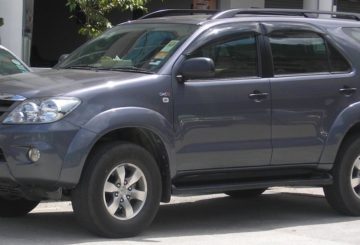 Foto mostrando a diagonal esquerda de um Toyota Hilux SW4 G3 estacionado.