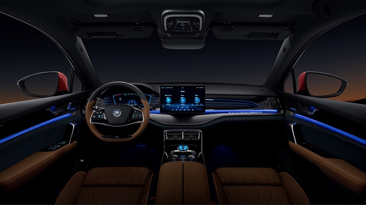 Foto interna do BYD Tan EV 2025, exibindo o painel de instrumentos, o volante multifuncional, central multimídia, parte dos bancos e das portas.