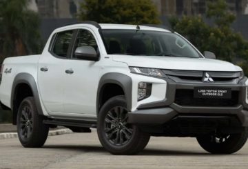 Foto frontal do Mitsubishi L200 Triton Sport Outdoor GLS 2025, exibindo a dianteira e a lateral do passageiro.