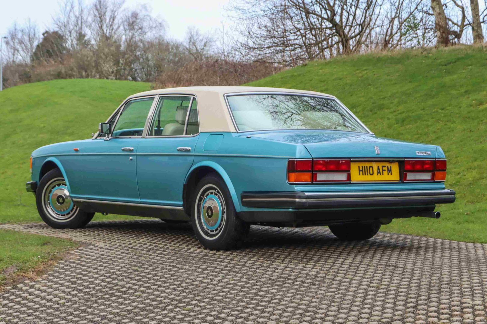 Foto traseira do Rolls-Royce Silver Spirit 1991, exibindo o porta-malas e a lateral do motorista.