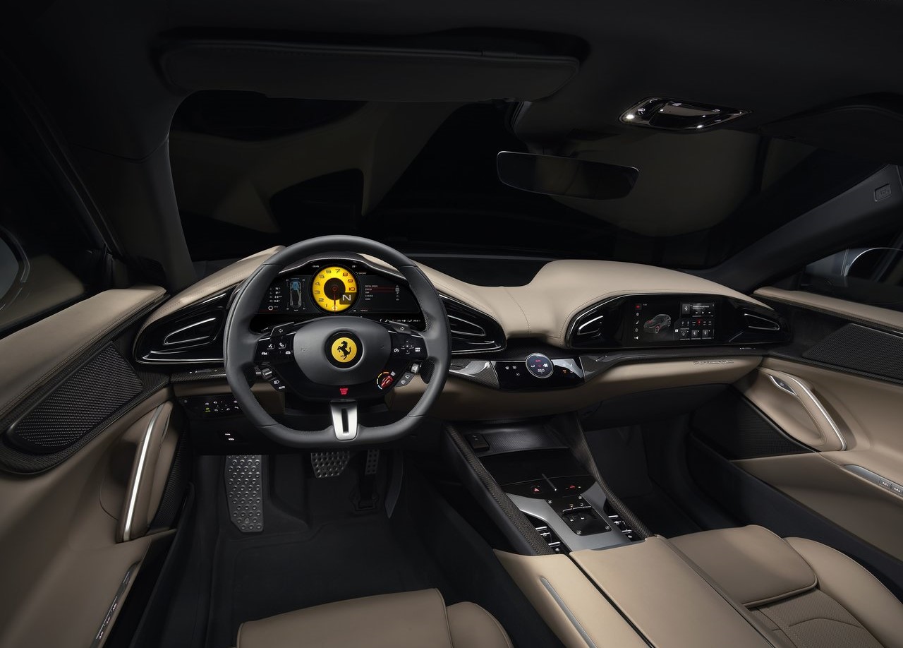 Foto interna da Ferrari Purosangue 2023, exibindo o painel de instrumentos digital, volante multifuncional, console central, multimídia para o passageiro, parte dos bancos e das portas.