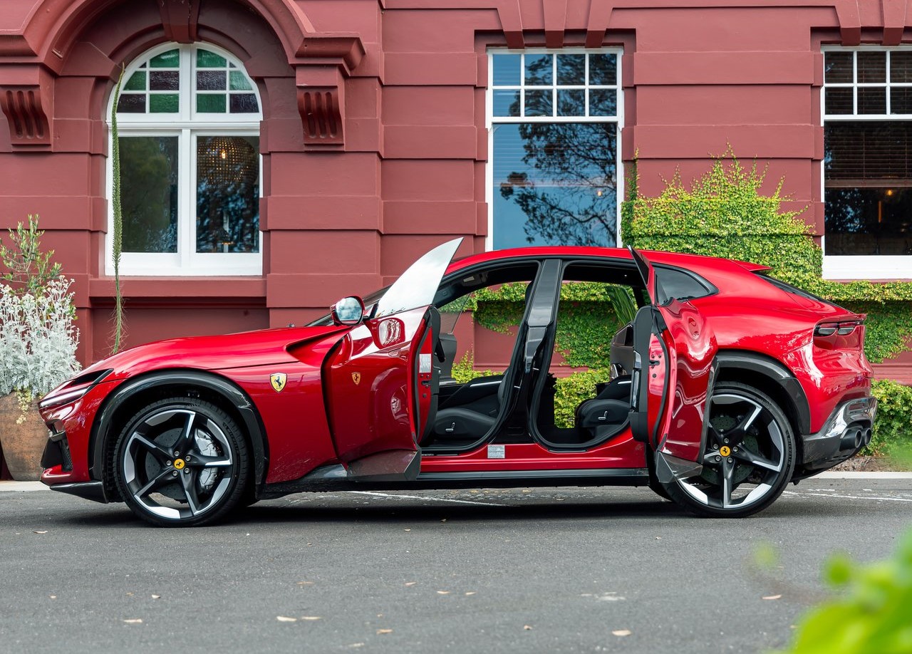 Foto lateral da Ferrari Purosangue 2023. exibindo toda a lateral com as portas abertas.