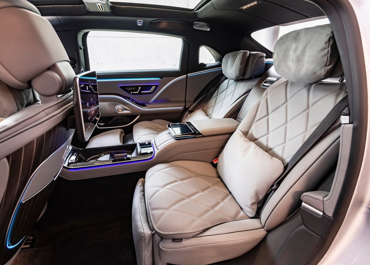 Foto dos bancos traseiros do Mercedes-Benz S 580e Maybach 2024, exibindo também as telas nos bancos reclináveis.