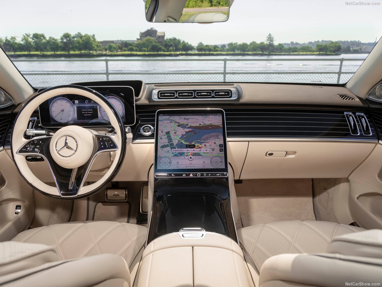 Foto interna do Mercedes-Benz S 580e Maybach 2024, exibindo o painel de instrumentos digital, volante multifunção, central multimídia, parte dos bancos e portas.