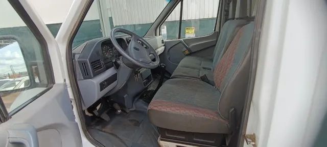 Foto interna do Mercedes-Benz Sprinter 310 furgão, exibindo o volante, parte do painel de instrumentos e dos bancos.