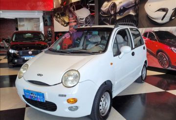 Foto frontal do CAOA Chery QQ, exibindo toda a dianteira e a lateral do motorista.