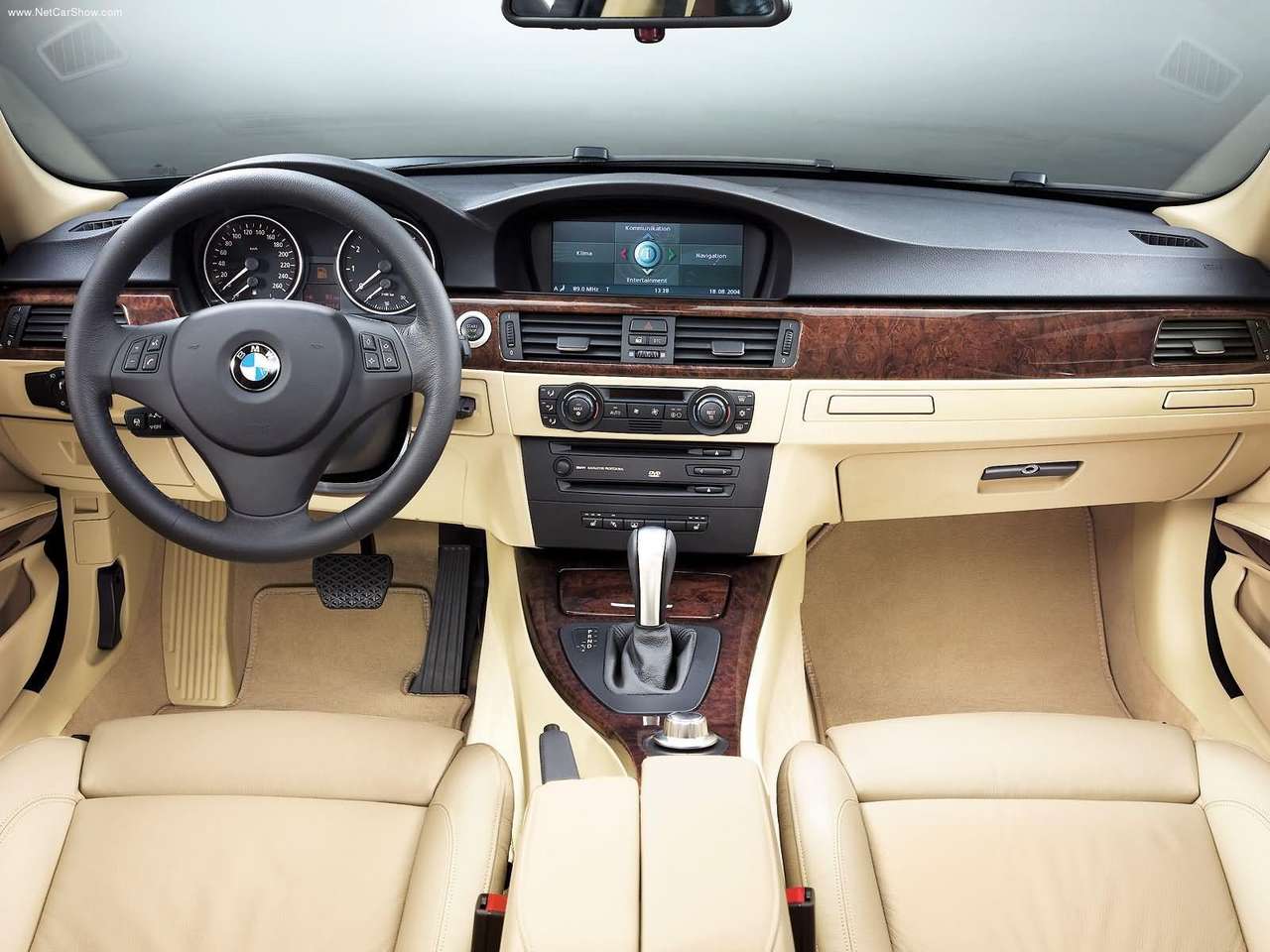 Foto interna do BMW 330i Exclusive 3.0 2006, exibindo o painel de instrumentos, volante multifuncional, parte do console central e bancos.