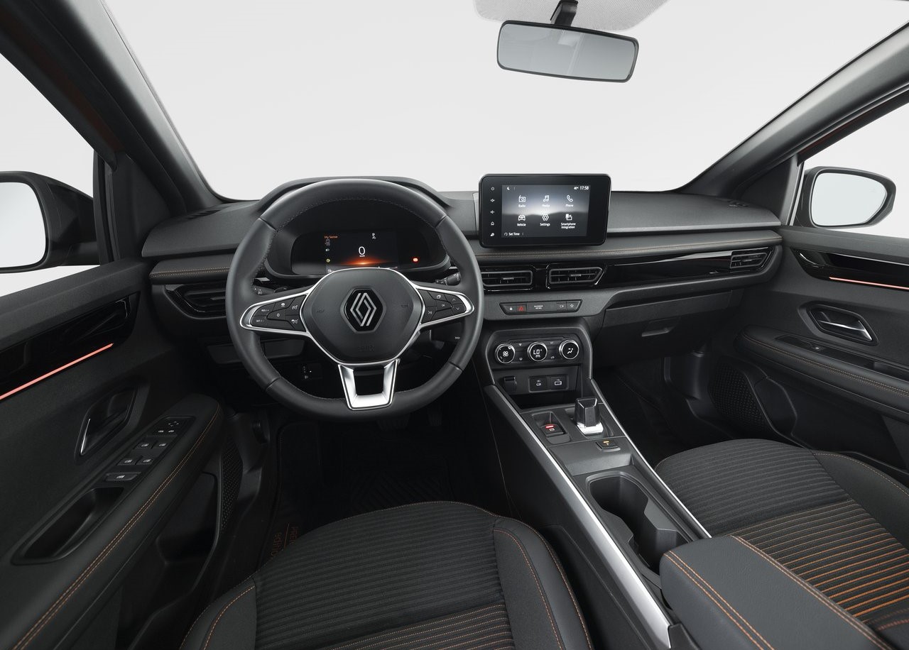 Foto interna do Renault Kardian Techno 2024, exibindo o painel de instrumentos digital, volante multifuncional, central multimídia, parte do console central e bancos.