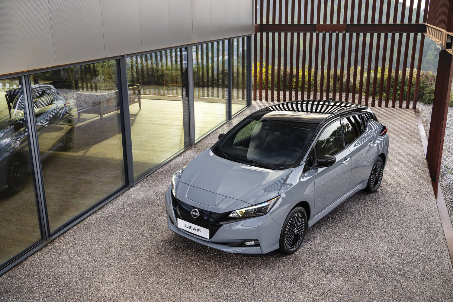 Foto exibindo a dianteira, lateral do motorista e teto do Nissan Leaf 2024.