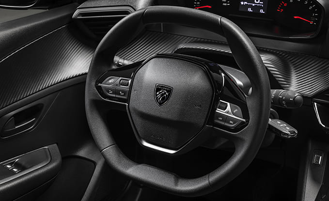 Foto exibindo o volante multifuncional e parte do painel de instrumentos do Peugeot 208 Active 1.0 MT 2025.