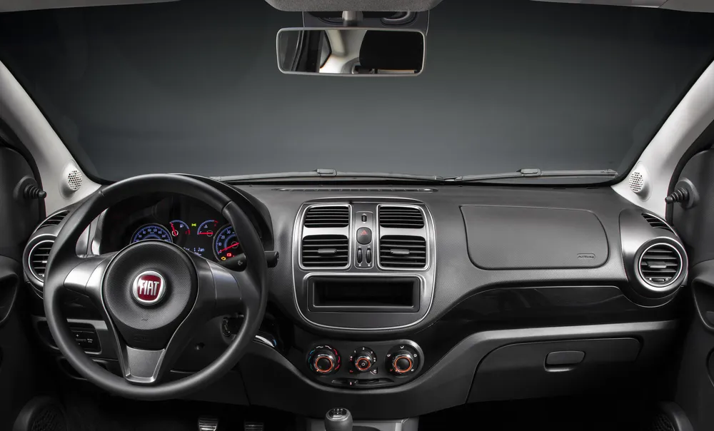 Foto interna do Fiat Grand Siena Tetrafuel 1.4, exibindo o painel de instrumentos, volante e parte do console central.