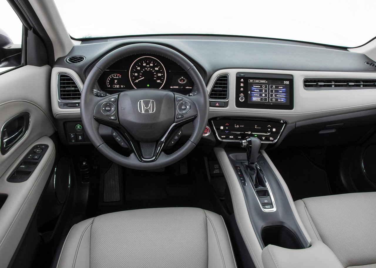 Foto interna do Honda HR-V EXL 2019, exibindo o painel de instrumentos, volante multifuncional, central multimídia, parte dos bancos e das portas.