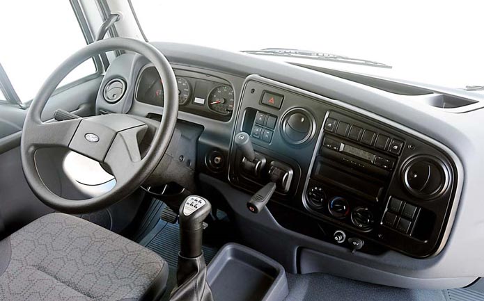 Foto interna do Ford Cargo 2422 (2007-2012), exibindo todo o painel e parte dos bancos.