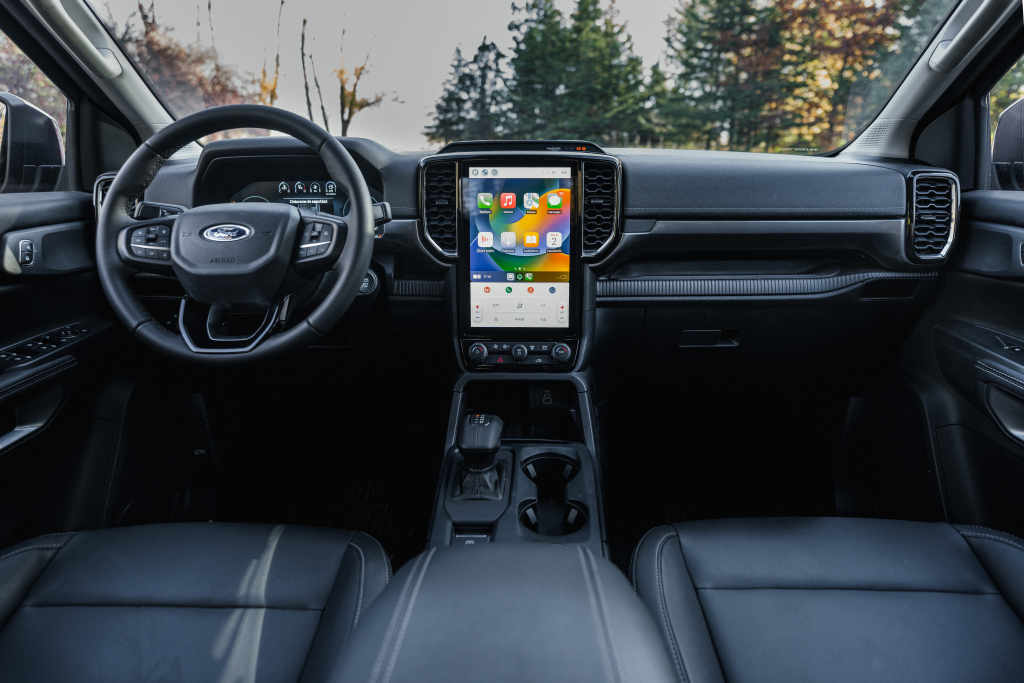 Foto do interior da Ford Ranger Limited 3.0 V6 4x4 2026, exibindo o painel de instrumentos digital, volante multifuncional, central multimídia, parte dos bancos e das portas.